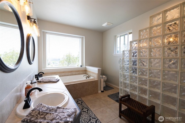 bathroom with toilet, tile patterned floors, a sink, and a bath