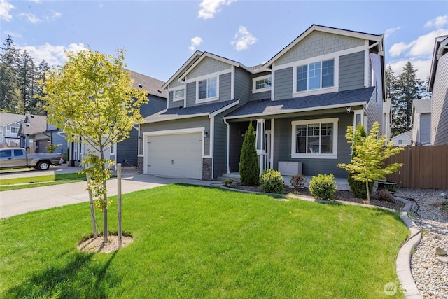 craftsman-style house featuring a garage, a front lawn, fence, stone siding, and driveway