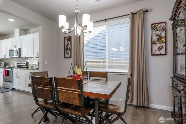 dining room with visible vents, dark wood finished floors, baseboards, and a chandelier