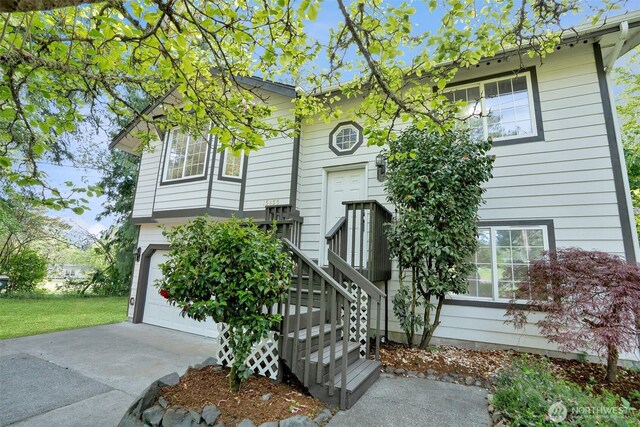split foyer home featuring a garage and concrete driveway