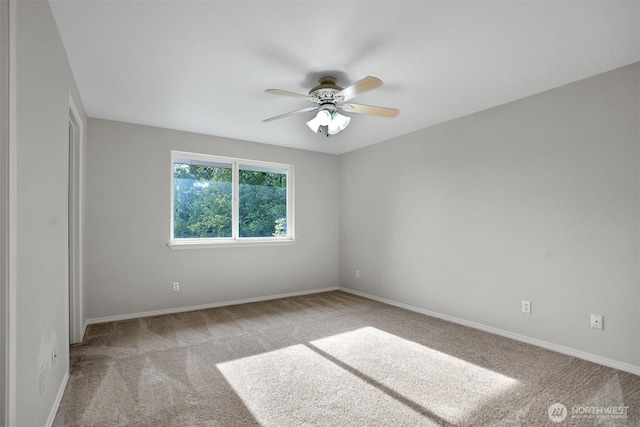spare room featuring a ceiling fan, carpet flooring, and baseboards