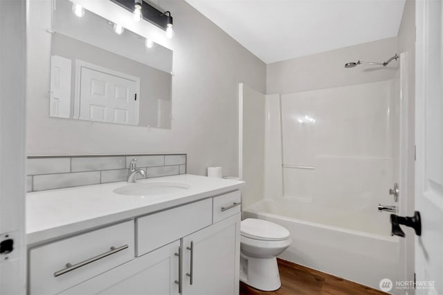 full bath with vanity, toilet, wood finished floors, and shower / bathtub combination