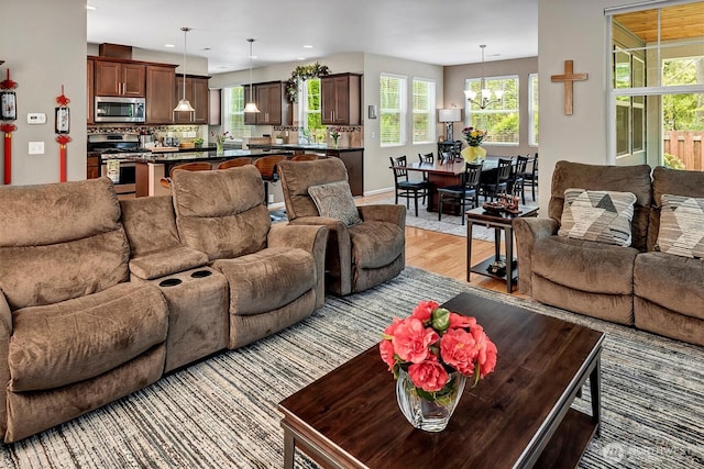 living room with recessed lighting, light wood finished floors, and a notable chandelier