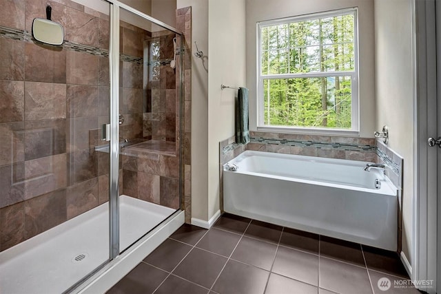 full bath with tile patterned floors, a shower stall, a healthy amount of sunlight, and a bath