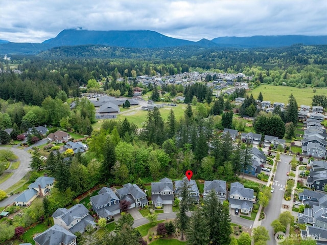 birds eye view of property featuring a forest view, a residential view, and a mountain view