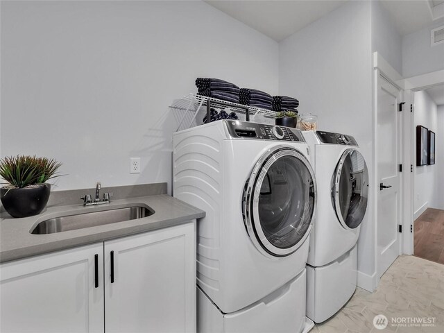 laundry room with independent washer and dryer, cabinet space, a sink, marble finish floor, and visible vents