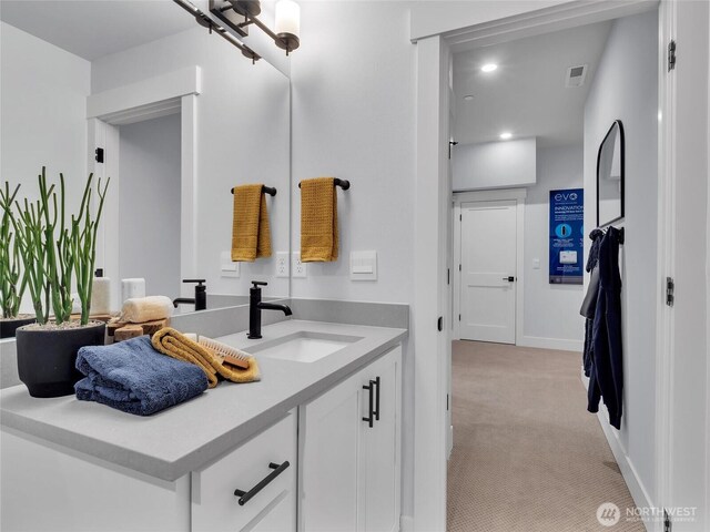 bathroom featuring vanity, baseboards, recessed lighting, and visible vents