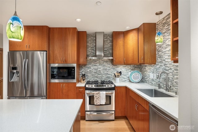 kitchen featuring a sink, light countertops, brown cabinetry, wall chimney exhaust hood, and stainless steel appliances