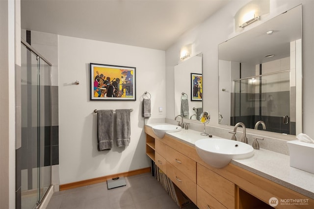 full bath with double vanity, a sink, tile patterned flooring, and a stall shower