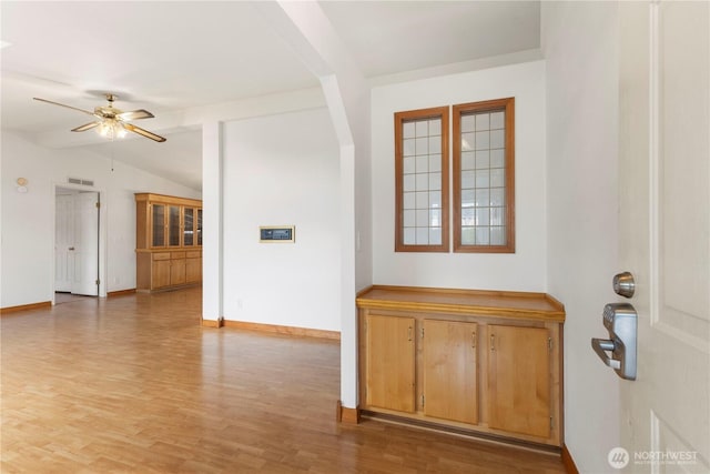 entrance foyer featuring a ceiling fan, visible vents, vaulted ceiling, light wood-type flooring, and baseboards