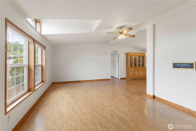 unfurnished room with baseboards, vaulted ceiling with beams, light wood finished floors, and ceiling fan