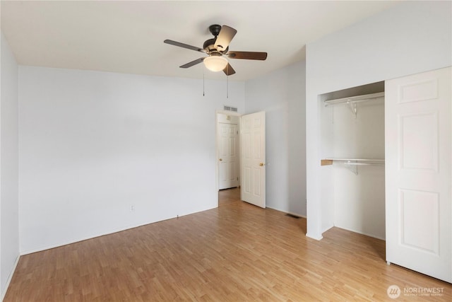 unfurnished bedroom with a ceiling fan, visible vents, light wood finished floors, and a closet