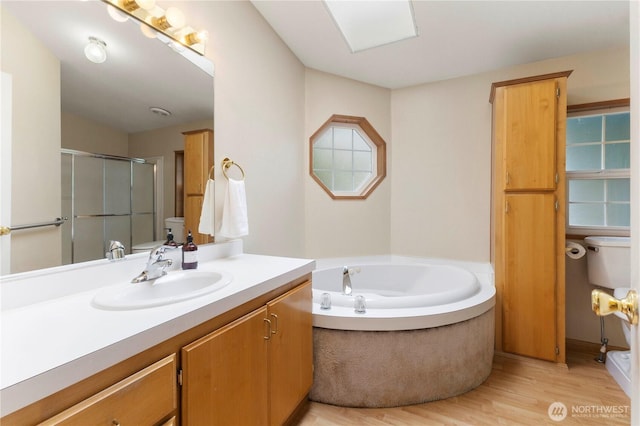 full bath with a garden tub, a stall shower, wood finished floors, vanity, and toilet