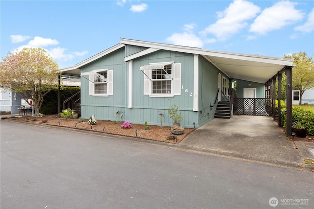 manufactured / mobile home featuring a carport and driveway