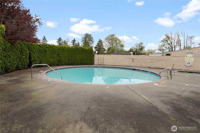 community pool featuring a patio area and fence