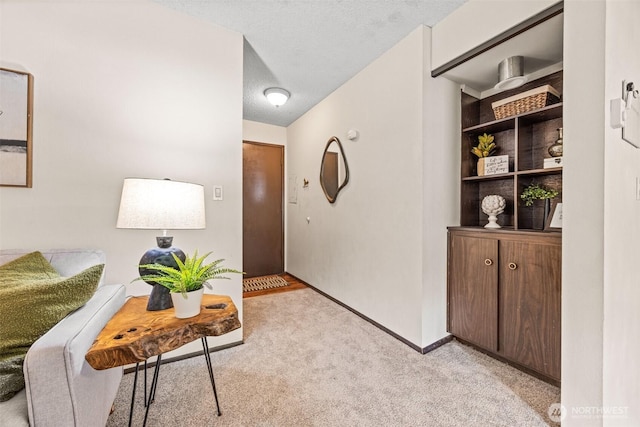 hallway with light colored carpet and baseboards