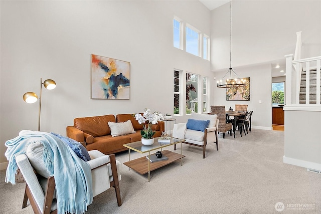living area with carpet flooring, baseboards, an inviting chandelier, and a high ceiling