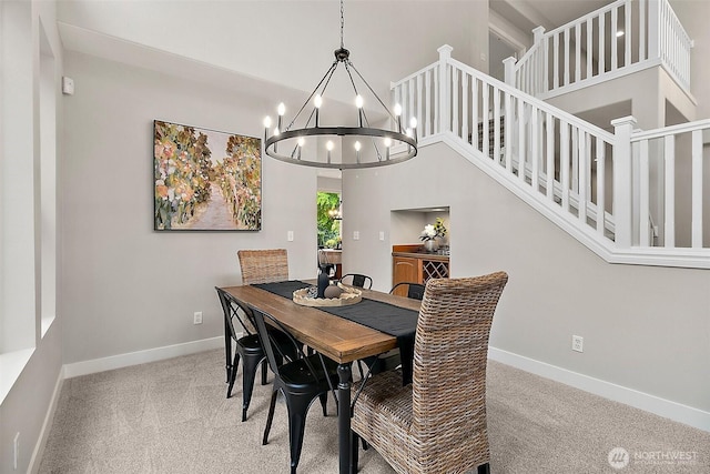 dining space with an inviting chandelier, carpet flooring, and baseboards