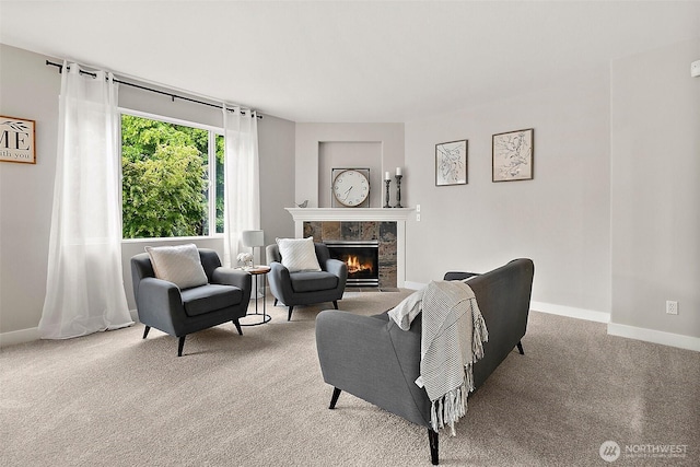 carpeted living area featuring baseboards and a premium fireplace