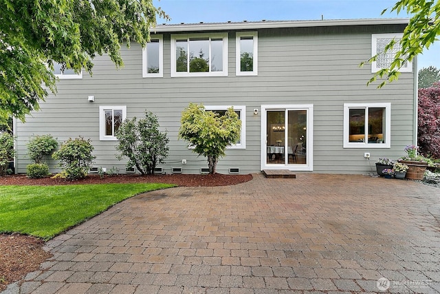 rear view of house featuring a lawn, a patio area, and crawl space