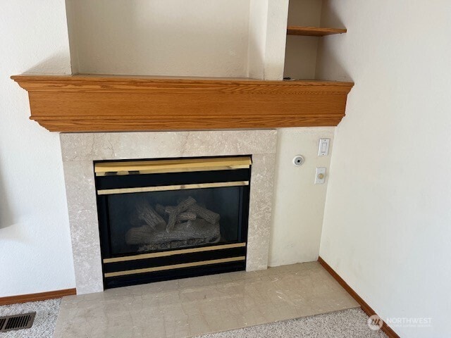 interior details with visible vents, carpet, baseboards, and a premium fireplace