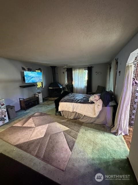2232 177th Pl SW, Lynnwood, WA 98037 - bedroom featuring a wood stove and a textured ceiling