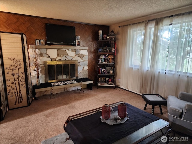 2232 177th Pl SW, Lynnwood, WA 98037 - living area with a textured ceiling, carpet flooring, a stone fireplace, and wood walls