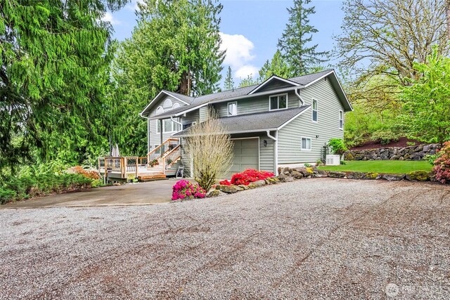 view of front of property featuring a chimney, roof with shingles, driveway, and a deck