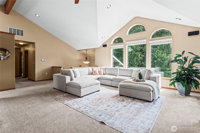 carpeted living area with visible vents, baseboards, high vaulted ceiling, and beamed ceiling