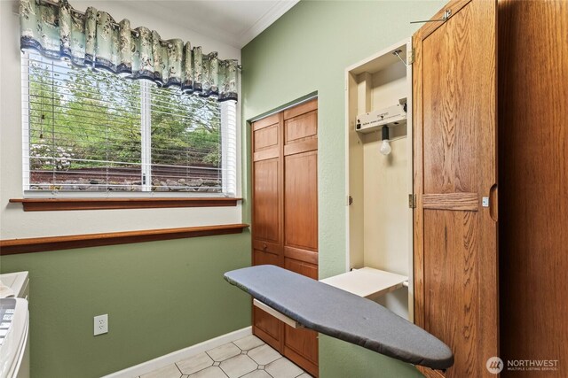 mudroom featuring crown molding, baseboards, and light floors