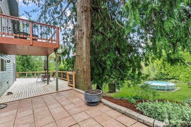 view of patio / terrace with a wooden deck and an outdoor pool