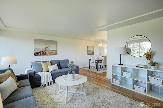living room featuring baseboards, an inviting chandelier, and wood finished floors