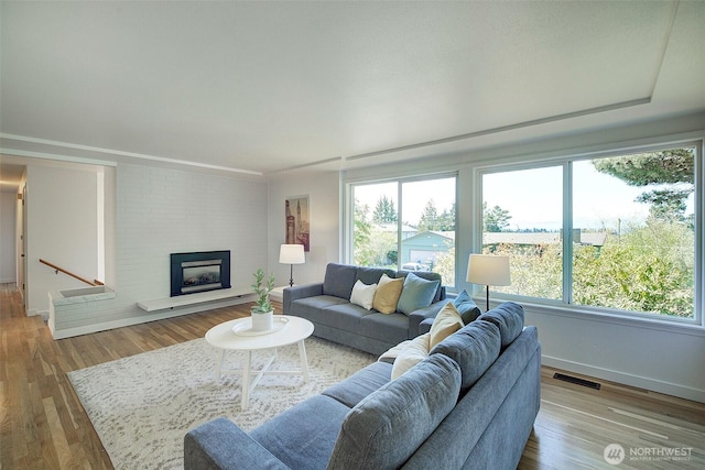 living area featuring a wealth of natural light, wood finished floors, and visible vents