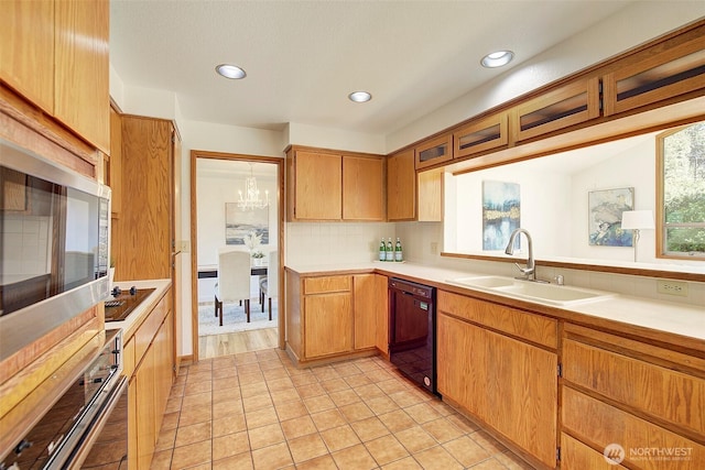 kitchen featuring a sink, light countertops, recessed lighting, backsplash, and black appliances