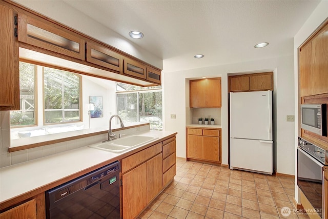 kitchen with a sink, dishwasher, freestanding refrigerator, wall oven, and stainless steel microwave