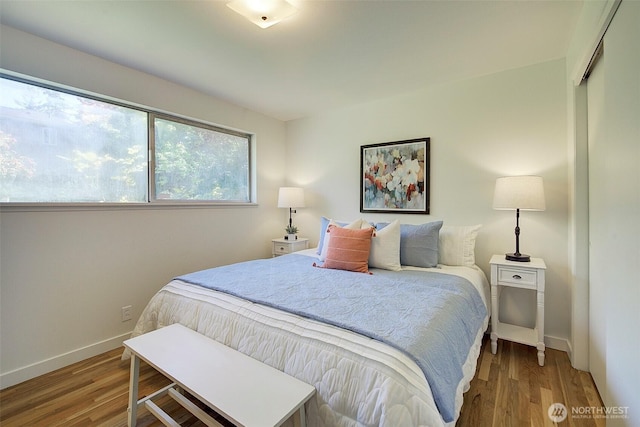 bedroom featuring baseboards and wood finished floors