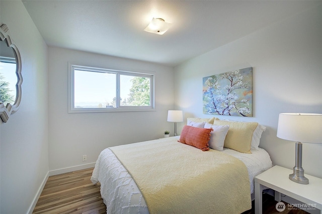 bedroom with baseboards and wood finished floors