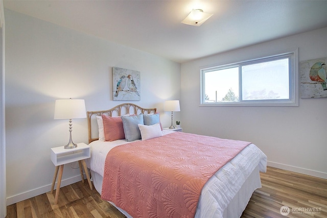 bedroom with baseboards and wood finished floors