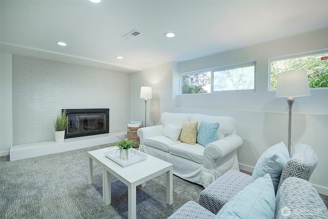 living area with a glass covered fireplace, carpet, recessed lighting, baseboards, and visible vents