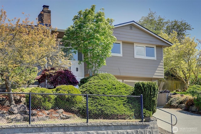 view of front of house with fence and a chimney