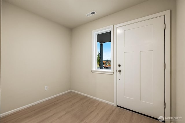 doorway with visible vents, light wood finished floors, and baseboards