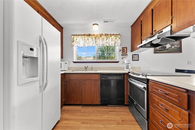 109 Lime St, Omak, WA 98841 - kitchen featuring visible vents, white appliances, light wood-style floors, light countertops, and under cabinet range hood