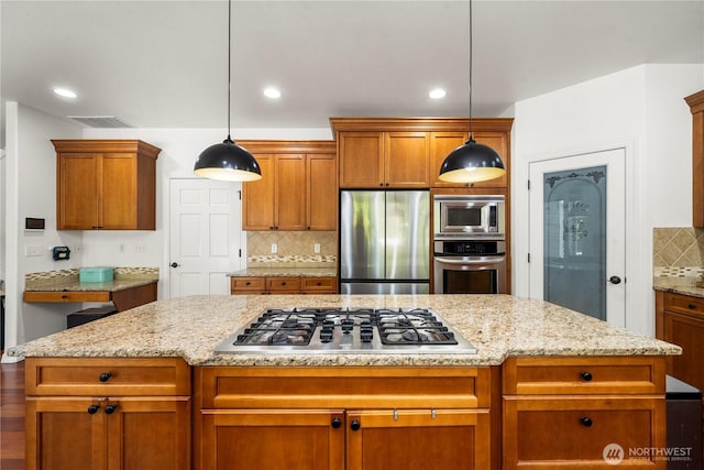 kitchen featuring a center island, backsplash, stainless steel appliances, and visible vents