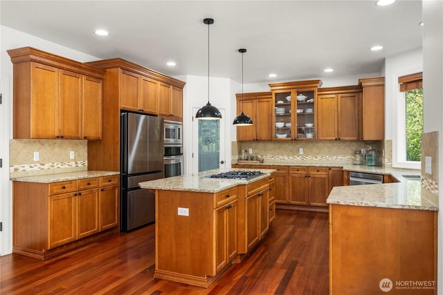 kitchen with brown cabinets, stainless steel appliances, and dark wood-type flooring
