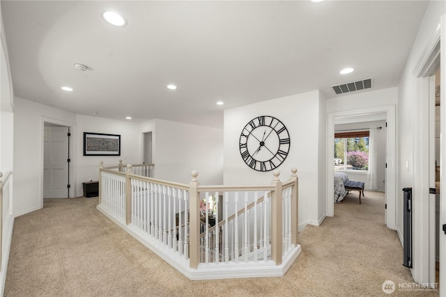 corridor with light carpet, recessed lighting, and an upstairs landing