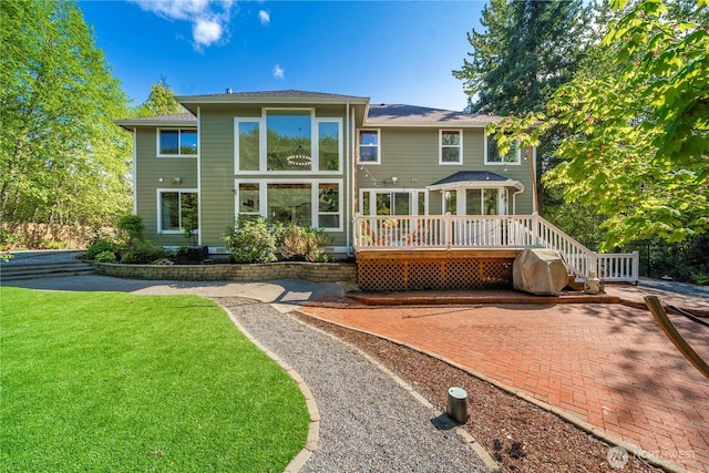 back of property featuring a lawn, a patio, and a deck