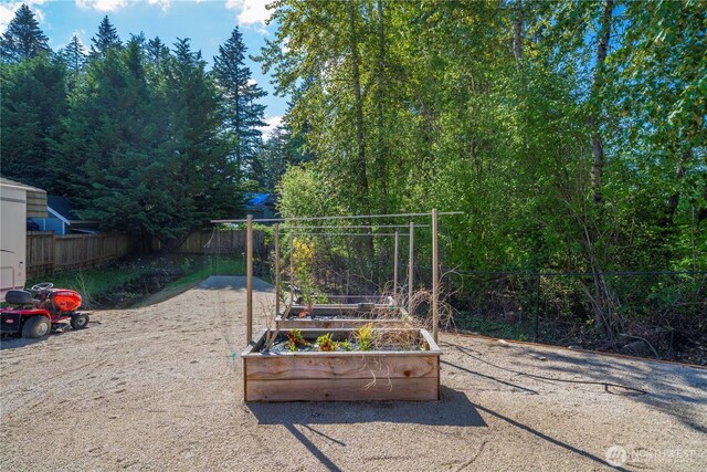 view of jungle gym with fence and a vegetable garden