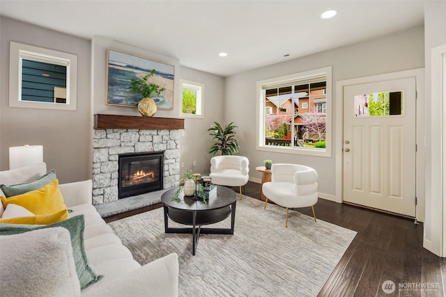 living area featuring visible vents, wood finished floors, a fireplace, baseboards, and recessed lighting