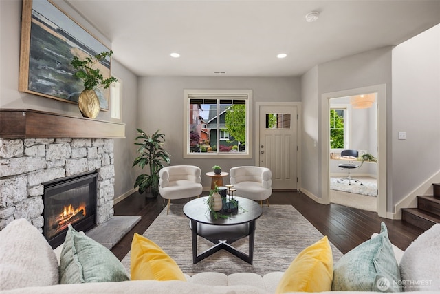 living area featuring baseboards, recessed lighting, wood finished floors, and a fireplace