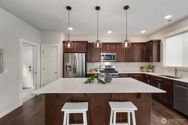 kitchen featuring a sink, tasteful backsplash, a breakfast bar, and stainless steel appliances